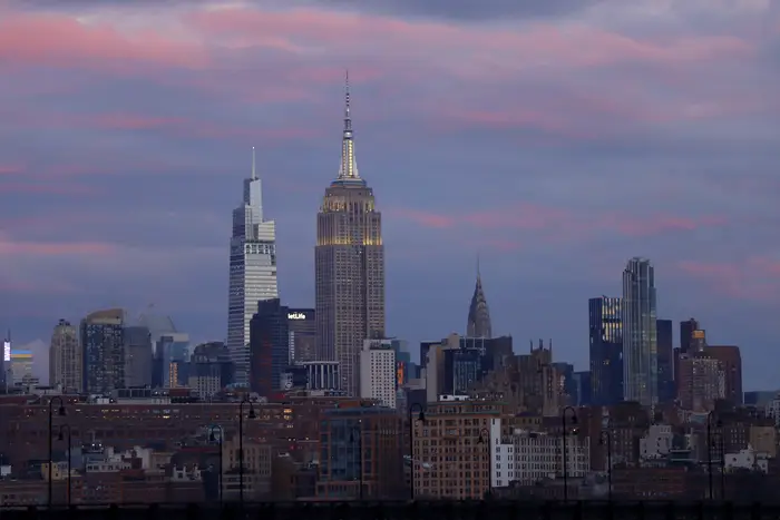 The sun sets on the skyline of midtown Manhattan and the Empire State Building, One Vanderbilt and the Chrysler Building in New York City on January 6, as seen from Jersey City, New Jersey.